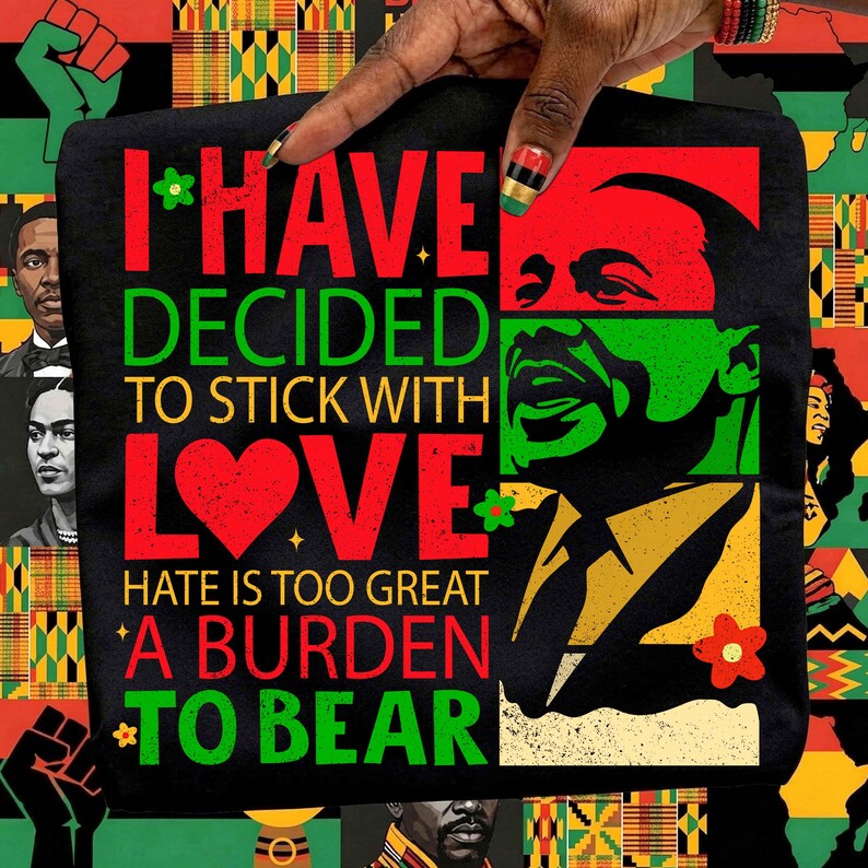 Puede incluir: Camiseta negra con la cita "I HAVE DECIDED TO STICK WITH LOVE. HATE IS TOO GREAT A BURDEN TO BEAR" en rojo y verde. El dise&ntilde;o incluye un coraz&oacute;n rojo y un retrato de un hombre en verde y negro. El fondo es un patr&oacute;n de inspiraci&oacute;n africana.