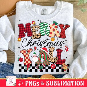 Pu&ograve; includere: Una felpa grigia con un design natalizio festoso. Il testo "Merry Christmas Y'all" &egrave; scritto in lettere colorate e con motivi. Il design include un pupazzo di neve, un cappello di Babbo Natale e un omino di pan di zenzero.