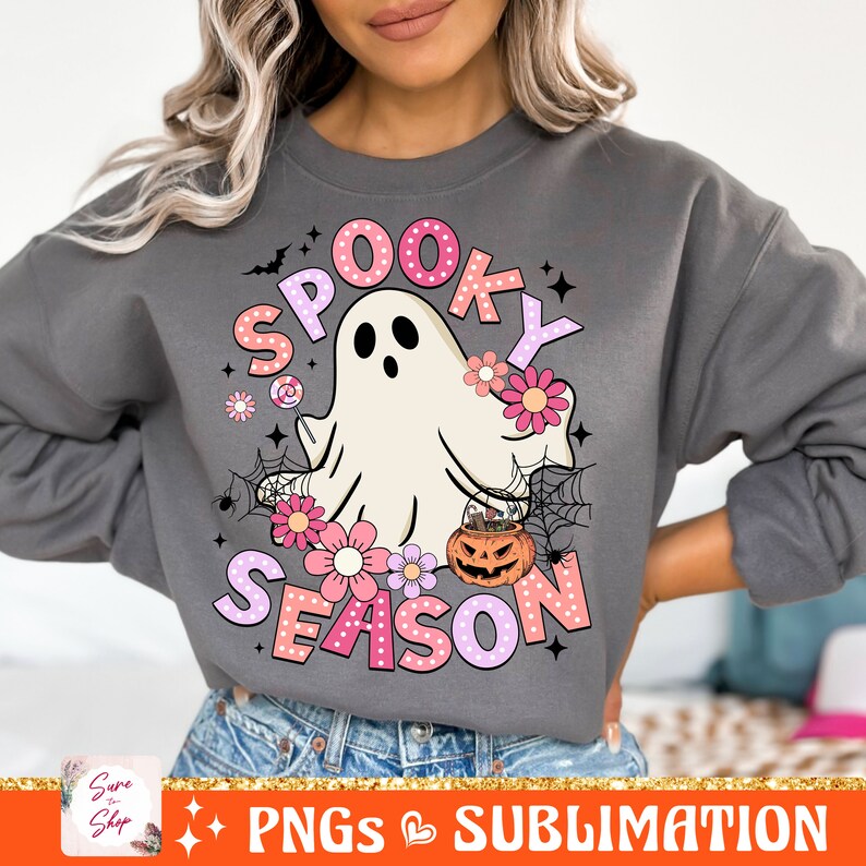 May include: A gray sweatshirt with a pink and white graphic design featuring a ghost, flowers, and the text "Spooky Season".