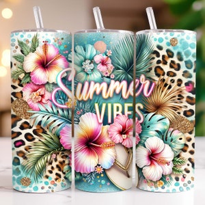 Puede incluir: Tres vasos de acero inoxidable con tapas y pajitas. Los vasos presentan un diseño tropical con flores de hibisco rosas y amarillas, hojas de palmera verdes y un estampado de leopardo. El vaso del medio tiene el texto "Summer Vibes" en letras rosas y amarillas.