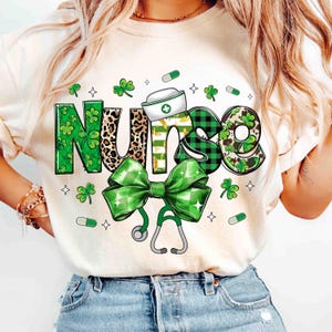 Pu&ograve; includere: Felpa color crema con un design a tema San Patrizio. La parola "NURSE" &egrave; scritta in verde, stampa leopardata e motivi a quadri, con un fiocco verde e uno stetoscopio. Include trifogli e grafica di pillole.