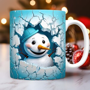 Peut inclure: Une tasse en c&eacute;ramique blanche avec un motif de bonhomme de neige bleu et blanc. Le bonhomme de neige sort d'un mur bleu fissur&eacute;.