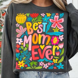May include: A charcoal gray sweatshirt with a colorful floral design and the text "Best Mom Ever" in a rainbow font.