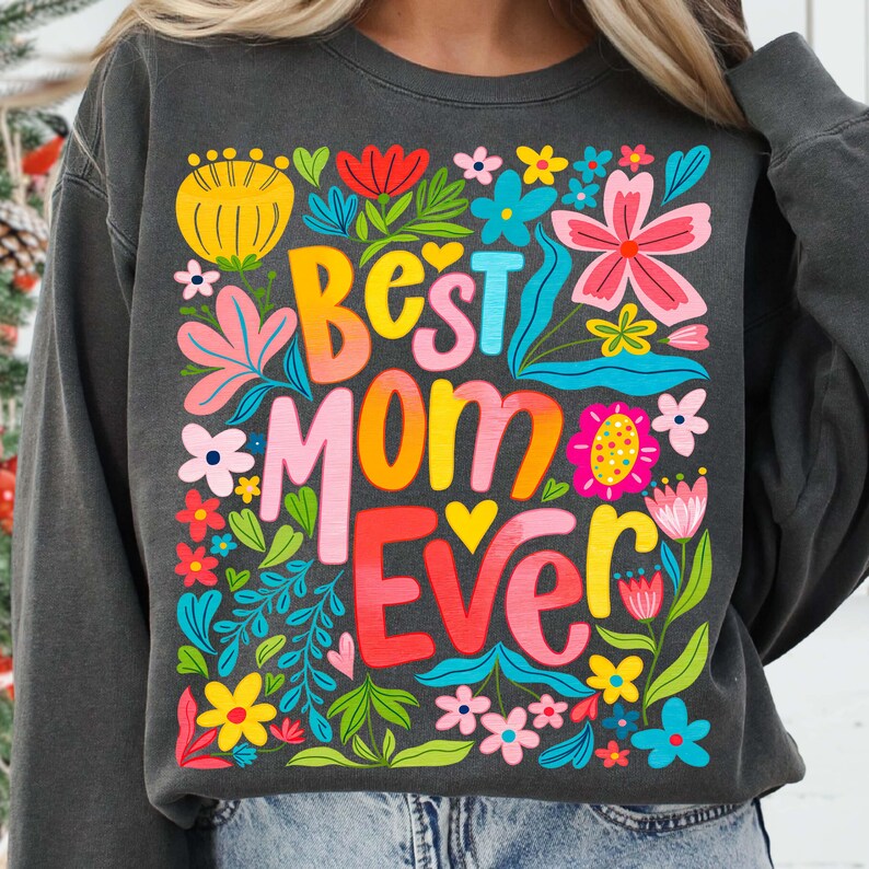 May include: A charcoal gray sweatshirt with a colorful floral design and the text "Best Mom Ever" in a rainbow font.