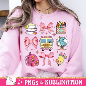 May include: Pink sweatshirt with a design of school supplies, including a backpack, books, a pencil, a globe, a bus, crayons, and bows.