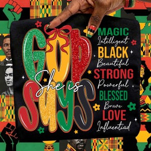 Puede incluir: Camiseta negra con la frase "GOD SAYS She is" en rojo, verde y amarillo, con palabras adicionales como "MAGIC" y "BLACK". El dise&ntilde;o se acent&uacute;a con motivos florales y de estrellas, y un lazo rojo.
