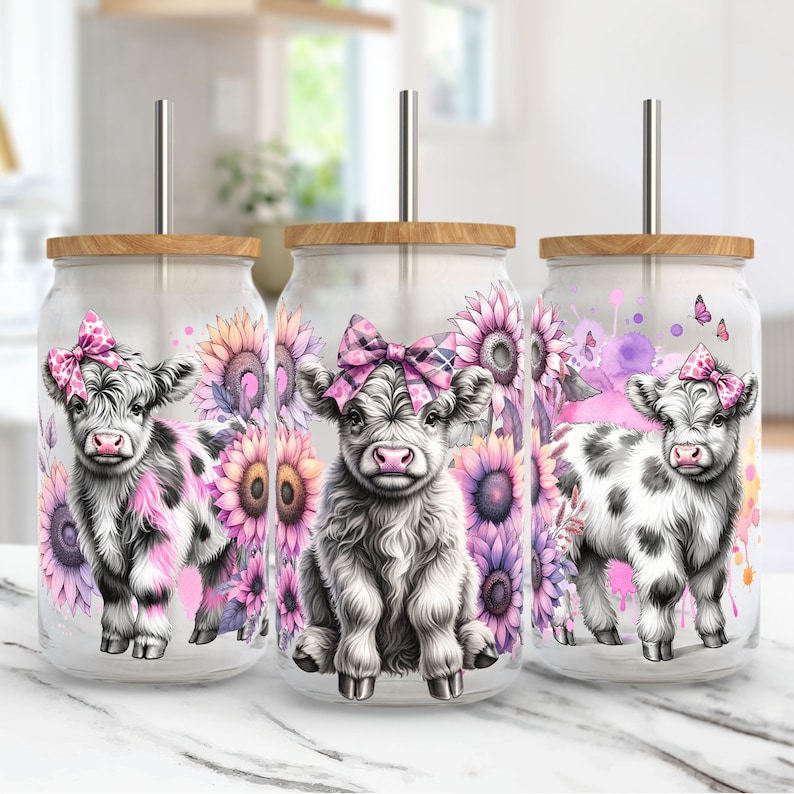 May include: Three stainless steel tumblers with lids and straws. Each tumbler features a different image of a Highland cow with a pink bow, surrounded by pink and yellow flowers.