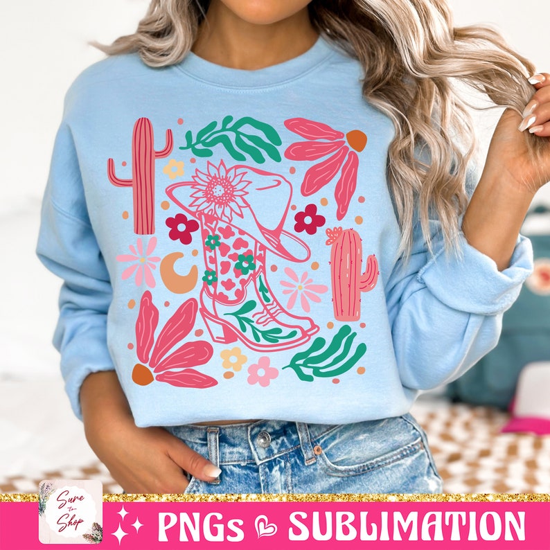 May include: Light blue sweatshirt featuring a colorful graphic of a cowboy boot, hat, cactus, and flowers. The design includes pink, green, and orange elements. The text "PNGs & SUBLIMATION" is at the bottom of the image.