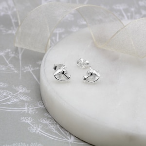 May include: A pair of silver horse head stud earrings. The earrings are small and delicate, and they would make a great gift for any horse lover.