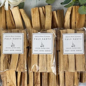May include: Three packages of Palo Santo sticks, each with a label that reads "Mellow Moon Crystals" and "Purify, Soothe, Energize." The sticks are light brown and arranged in bundles.