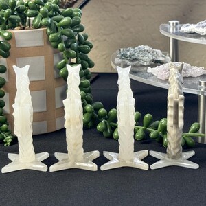 Puede incluir: Cuatro candelabros de cristal blanco tallados con una base en forma de estrella. Cada candelabro tiene un dise&ntilde;o &uacute;nico e intrincado.