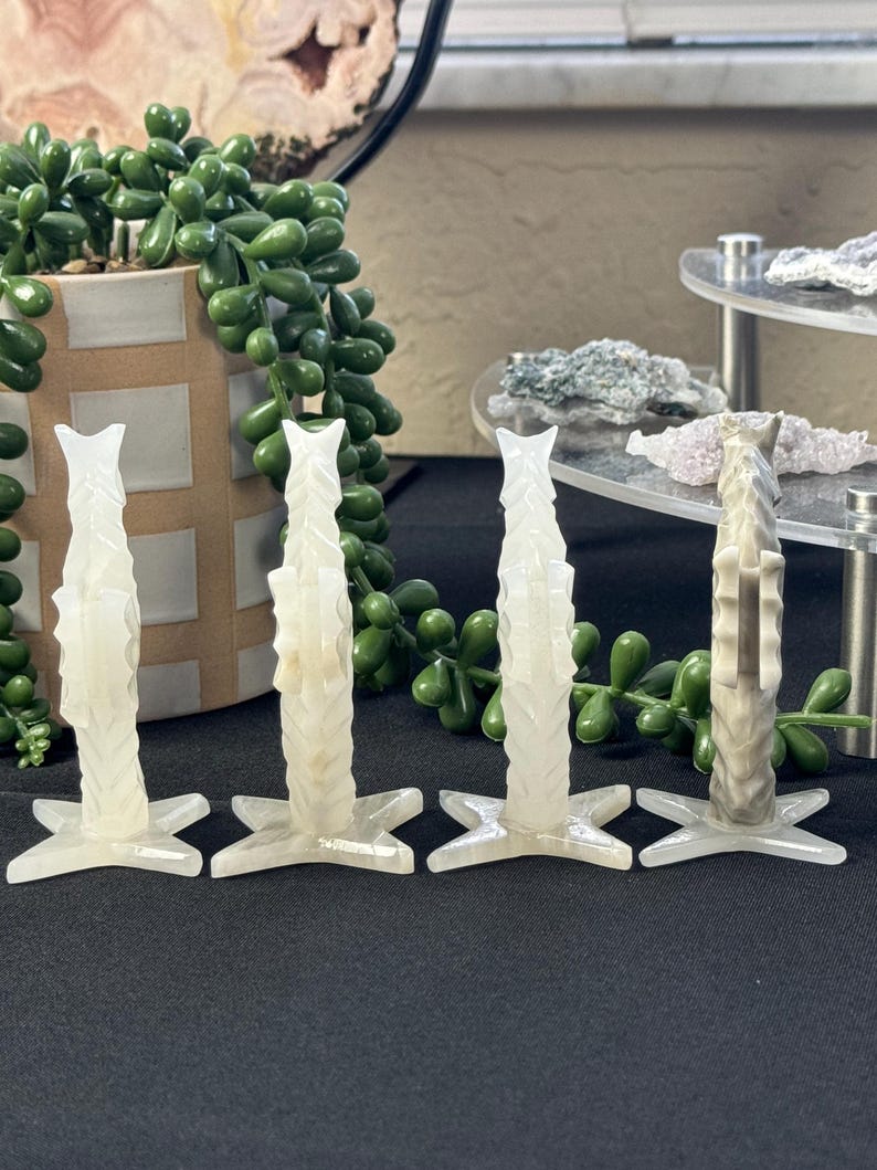 Puede incluir: Cuatro candelabros de cristal blanco tallados con una base en forma de estrella. Cada candelabro tiene un dise&ntilde;o &uacute;nico e intrincado.