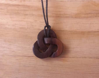 Beautifully handmade Celtic Knot pendant made from recycled wood hung on a adjustable waxed cotton thong and measuring 3cm