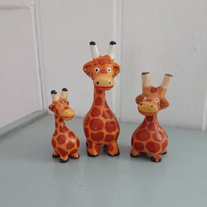 A Individually carved and handpainted family of cute wooden Giraffes.(12/8/6cm)