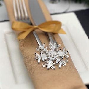 Gepersonaliseerde kerstsneeuwvlokcouverts, in spiegel gegraveerde namen. Chique op maat gemaakte stoelkaarten idee voor feestelijke tafeldecoratie