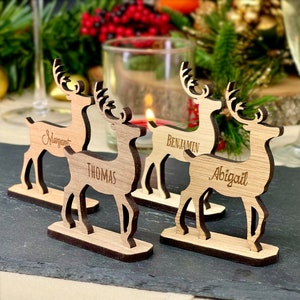 Couverts personnalisés rennes de Noël, noms gravés en bois sur le support. Idée de décorations de table festives avec cartes de siège personnalisées rustiques