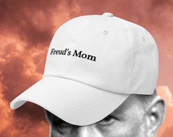 May include: White baseball cap with the text "Freud's Mom" embroidered in black on the front.