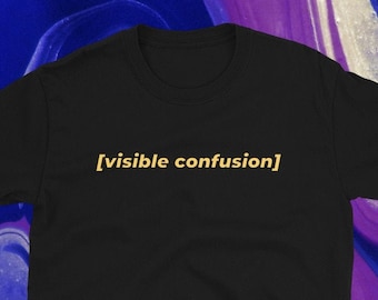 May include: Black t-shirt with the text "[visible confusion]" in a light orange color. The shirt is made of a soft material and is displayed against a background of swirling blue, purple, and white colors.