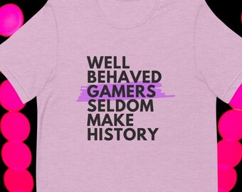 May include: A light purple t-shirt with the text "WELL BEHAVED GAMERS SELDOM MAKE HISTORY" printed in black.