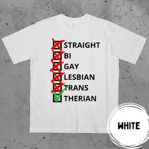 Puede incluir: Camiseta blanca con texto negro y cruces rojas sobre las palabras "Straight", "Bi", "Gay" y "Lesbian". Una marca de verificación verde está sobre la palabra "Therian". La palabra "WHITE" está en un círculo blanco.