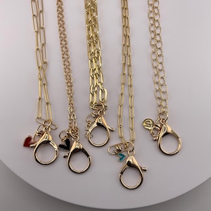 Este é para comprimento de 30” - 32”. Lindo cordão dourado único. Faz com que usar seu distintivo seja uma declaração! Diferentes opções de correntes e pingentes.