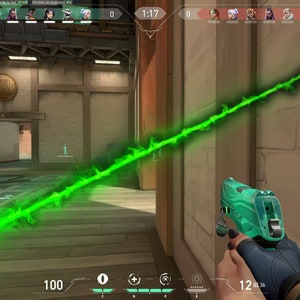 Op de afbeelding: Een groene energiebundel schiet door een videogame-sc&egrave;ne. De speler houdt een teal en zwart pistool vast met een digitaal display dat 12 resterende kogels aangeeft.