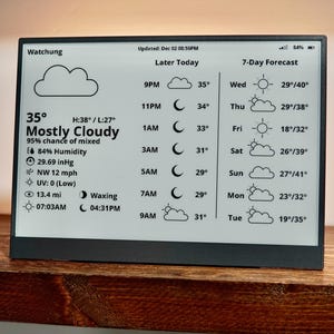 May include: A digital weather station displays current conditions: 35 degrees, mostly cloudy, 84% humidity, and a 7-day forecast. The screen shows the time, temperature, and weather icons. The device is on a wooden shelf.