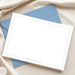 May include: A white stationery card with a light blue border and matching envelope. The card features the names "EMILY & DAVID" in a delicate font. The words "new blue ink and envelope" are in the lower left corner.