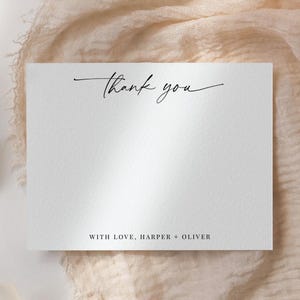 May include: White thank you card with black calligraphy that says "Thank you" and the text "With love, Harper + Oliver" at the bottom.