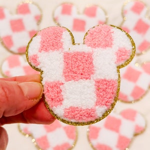 May include: Pink and white gingham fabric Mickey Mouse ears with a gold glitter outline.
