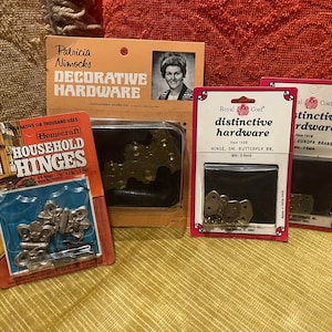 May include: Assortment of decorative hardware, including hinges, butterfly hinges, and Europa brass hinges. The packaging features the brand name "Royal Coat" and the text "distinctive hardware".