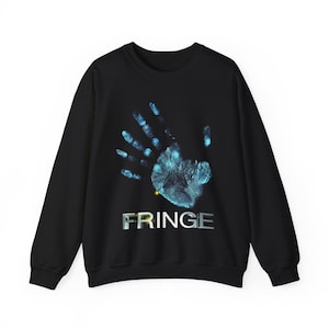 May include: Black sweatshirt featuring a glowing blue handprint design. The word "FRINGE" is printed in silver block letters below the handprint. The sweatshirt has a crew neck and long sleeves.