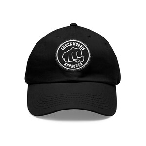 Puede incluir: Gorra de béisbol negra con un parche bordado blanco que dice "Chuck Norris Approved" y presenta un puño.