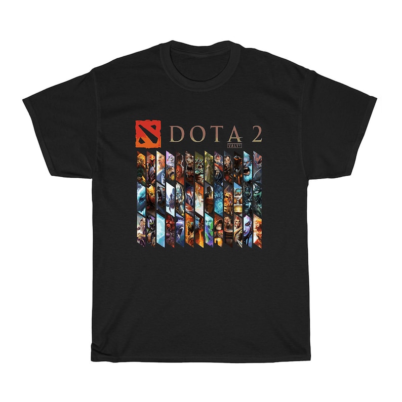 Pu&ograve; includere: T-shirt nera con il logo "DOTA 2" e un collage di personaggi del gioco. Il design include il logo del gioco in arancione e il testo "DOTA 2" in un font serif. La maglietta &egrave; realizzata in un materiale morbido e confortevole.