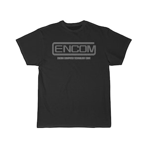May include: Black t-shirt featuring a white graphic of the ENCOM Computer Technology Corp. logo. The logo is a stylised wordmark with the letters ENCOM in a box.