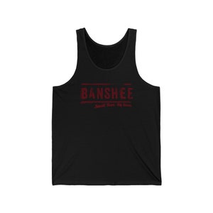 Op de afbeelding: Zwart tanktop met een rode afbeelding met de tekst "Banshee" en daaronder de tekst "Small Town, Big Secrets".