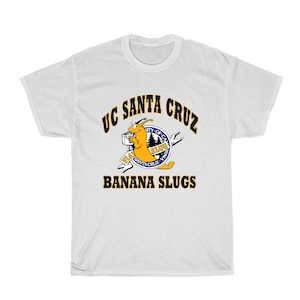May include: White t-shirt with a blue and yellow graphic of a cartoon banana slug holding a newspaper. The graphic includes the text "UC Santa Cruz Banana Slugs".