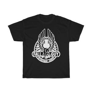 May include: Black t-shirt with a white graphic of a stylized eagle with the text "Fall Guy Stuntman Assoc."