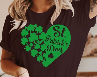 May include: A brown t-shirt with a green shamrock heart design that says "St. Patrick's Day" in black text.