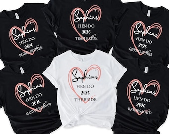 May include: A collection of black and white t-shirts with a heart design and the text "Sophia's Hen Do 2026". The shirts are labeled "Team Bride", "Bridesmaid", "Maid of Honour", "Groom's Mother", "Bride's Mother", and "The Bride".