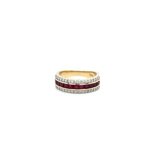 May include: A gold ring with three rows of gemstones. The top and bottom rows are encrusted with small, clear gemstones, while the middle row features square-cut, deep red gemstones. The ring is set against a white background.
