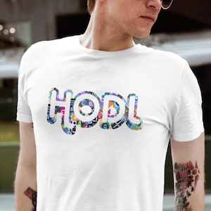 May include: A white t-shirt with a colourful graphic of the word "HODL" printed on the front.