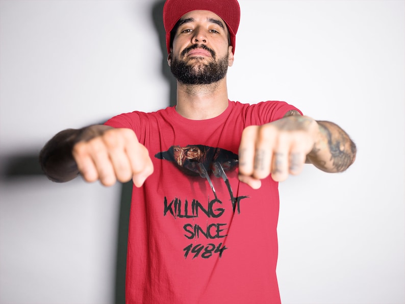 K&ouml;nnte beinhalten: Rotes T-Shirt mit einem schwarz-wei&szlig;en Motiv eines Vogels mit dem Text "KILLING IT SINCE 1984".