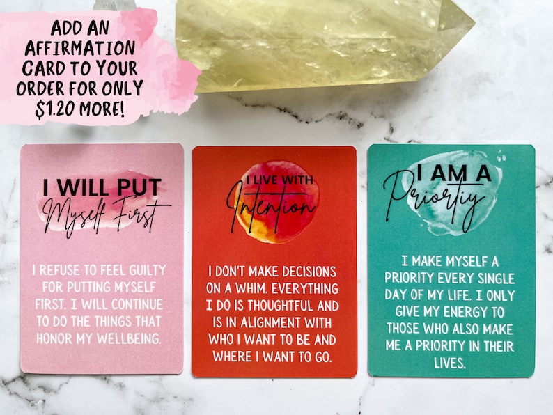 May include: Three affirmation cards with watercolor backgrounds. The first card is pink and says "I will put myself first". The second card is red and says "I live with intention". The third card is teal and says "I am a priority".