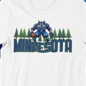 May include: White t-shirt with a blue and green graphic of a wolf basketball player with the word "MINNESOTA" printed below.