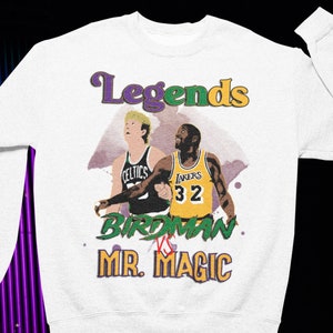 May include: White sweatshirt with a graphic of two basketball players, Larry Bird and Magic Johnson, with the text "Legends Birdman vs Mr. Magic".