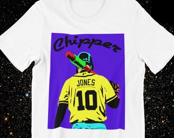 May include: White t-shirt with a colorful graphic of a baseball player holding a bat. The graphic has the text "Chipper" and "Jones 10" on it.