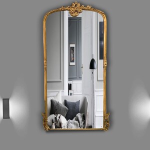 , this antique-inspired mirror adds an elegant touch to any space. With its gold, copper, or silver gilded frame, the mirror features intricate carvings.
