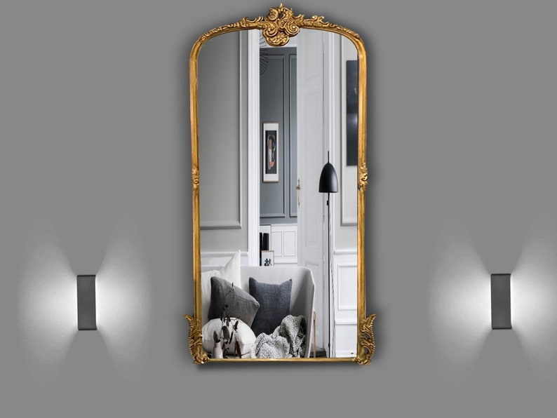 , this antique-inspired mirror adds an elegant touch to any space. With its gold, copper, or silver gilded frame, the mirror features intricate carvings.
