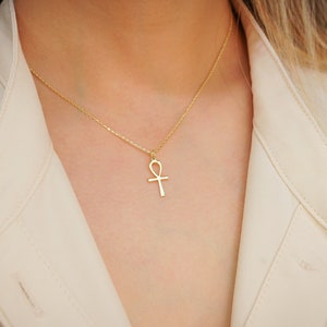 K&ouml;nnte beinhalten: Eine goldene Kettenkette mit einem Ankh-Anh&auml;nger.